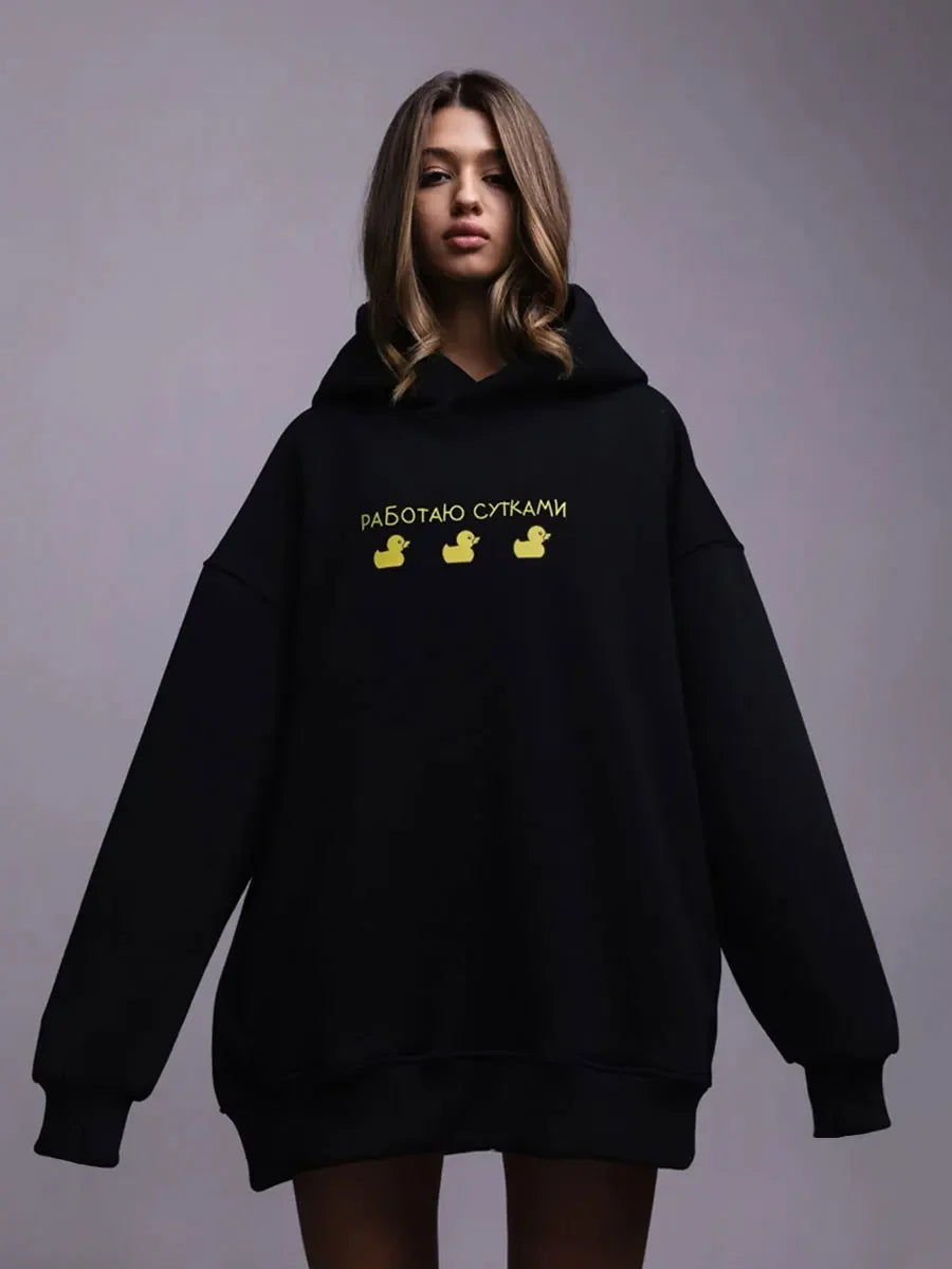 Model wearing an oversized hoodie in black featuring yellow graphic text, showcasing the stylish Oversized Hoodie Warm Sweatshirt.