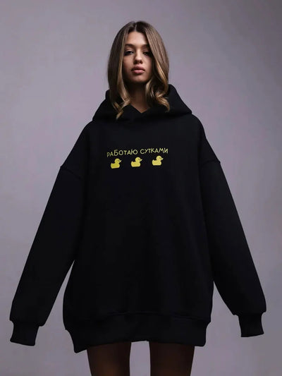 Model wearing an oversized hoodie in black featuring yellow graphic text, showcasing the stylish Oversized Hoodie Warm Sweatshirt.